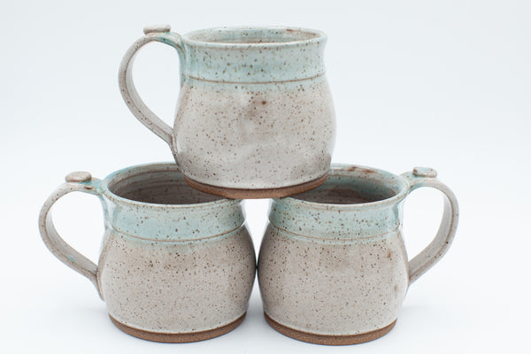 Mug in speckled clay with spiced cream and teal glaze