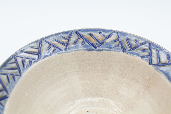 Bowl with carved rim in spiced cream and blue glaze