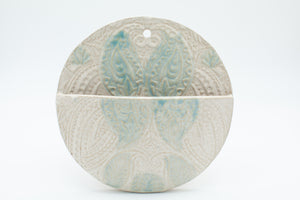 Round wall pocket with spiced cream and teal glaze