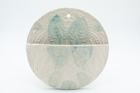 Round wall pocket with spiced cream and teal glaze