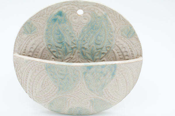 Round wall pocket with spiced cream and teal glaze