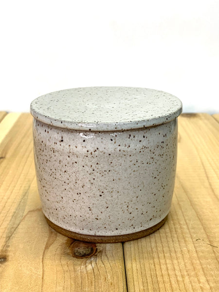 Close up of speckled clay butter keeper with spiced cream glaze texture