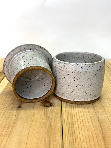 Close up of speckled clay butter keeper with spiced cream glaze texture