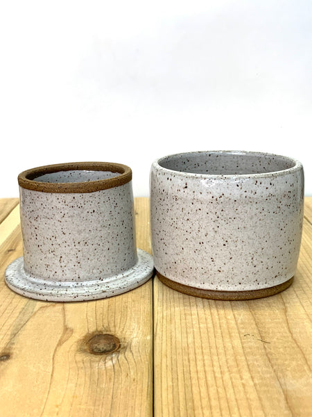 Close up of speckled clay butter keeper with spiced cream glaze texture