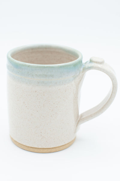 Handmade stoneware mug in buff clay with spiced cream and teal glaze